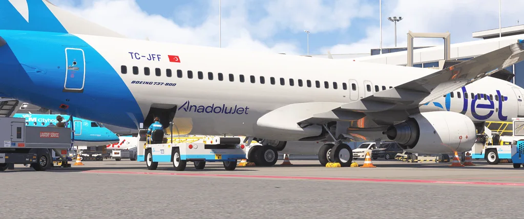 Aircraft at Flight Simulation Showcase with airline branding and ground support vehicles.
