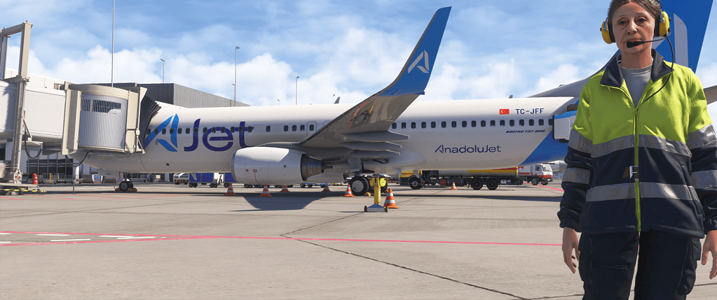 B737 Aircraft and pilot at Flight Simulation Showcase with a commercial airplane in the background.